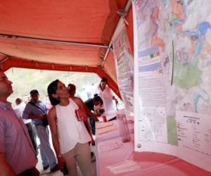 Roque Andrade, jefe de operaciones de Los Laureles, y Nívida Hernández, directora de la junta interventora del SANAA, observan un mapa del Distrito Central.