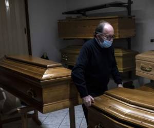 Revello, Italia: el propietario de la empresa de funerarias 'Palmero' Giampiero Palmero saca un ataúd el 24 de abril de 2020 en las oficinas de su empresa en Revello, cerca de Cuneo, en el noroeste de Italia, durante el cierre del país destinado a frenar la propagación de la infección por COVID-19 , causado por el nuevo coronavirus. / AFP / MARCO BERTORELLO