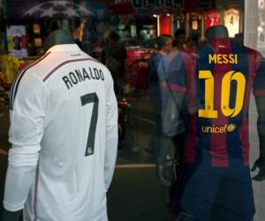 (FILES) This file photo taken on October 23, 2014 shows two store mannequins sporting the jerseys of Real Madrid's Portuguese forward Ronaldo Cristiano (L) and Barcelona's Argentinian forward Lionel Messi in a shop window at Puerta del Sol, in the centre of Madrid.Madrid will host Barca for a Clasico on April 23, 2017 with a three-point lead at the top of La Liga and with a game in hand. / AFP PHOTO / SEBASTIEN BERDA