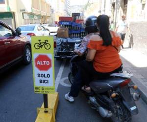 Motocicletas y carros estacionados se observan en el carril exclusivo para la ciclovía en la avenida Cervantes.