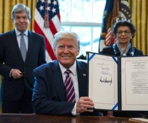 Momento en que el mandatario hacía la firma del paquete económico. Foto: AP