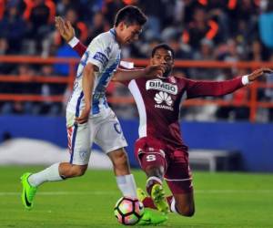 Irving Lozano del Pachuca pelea una pelota con Davr Myrie del Saprissa. / AFP PHOTO / ROCIO VAZQUEZ