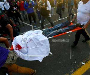 Un manifestante muerto que recibió un disparo en la cabeza es trasladado por paramédicos luego de que estallaron enfrentamientos durante una marcha contra el presidente de Nicaragua Daniel Ortega en Managua, Nicaragua, el miércoles 30 de mayo de 2018. (Foto referencial AP).