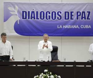 El presidente Juan Manuel Santos y el comandante de las Fuerzas Armadas Revolucionarias de Colombia (FARC), 'Timoleón Jimenez' o 'Timochenko' firman en esta capital el convenio para detener las hostilidades, el paso más significativo hacia un acuerdo definitivo de paz en una fecha próxima.