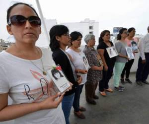 Carolina Oyague, pariente de una de las víctimas del brutal régimen de Alberto Fujimori, sostiene el retrato de su hermana.