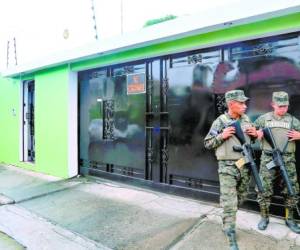 Elementos de las Fuerzas Armadas montan guardia en una casa de la colonia Trejo de San Pedro Sula donde se encontraron los tres carros de lujo.