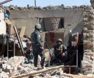 TOPSHOT - Afghan policemen gather at the site of a suicide bombing attack on the police headquarters in Gardez, capital of Paktia province, on June 18, 2017.At least five Afghan policemen were killed and 15 people injured in the suicide bomb and gun attack by Taliban insurgents on June 18, authorities said. / AFP PHOTO / FARID ZAHIR