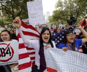 FILE - In this Feb. 28, 2017, file photo, Georgia Cordova of El Paso, Texas, center, joins other protesters as they take part in a No Ban, No Wall rally to support the rights of immigrants and oppose a border wall and support sanctuary cities at the State Capitol in Austin, Texas. Immigrant activists who lived under a now-overturned anti-“sanctuary cities” law in Arizona that empowered police to inquire about peoples’ immigration status during routine interactions like traffic stops are visiting Texas to offer tips on how to cope with similar restrictions the state’s Republican-controlled Legislature recently approved. (AP Photo/Eric Gay, File)