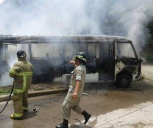Personal del Cuerpo de Bomberos mientras sofocaban las llamas que consumieron casi en totalidad el autobús.
