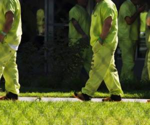 Men wearing neon-colored jail clothes signifying immigration detainees walk to pick up their lunches at the Theo Lacy Facility, a county jail which houses convicted criminals as well as immigration detainees, March 14, 2017 in Orange, California, about 32 miles (52km) southeast of Los Angeles.US President Donald Trumps first budget provides more than USD 4.5 billion in new spending to fight illegal immigration by adding immigration and border enforcement agents, prosecutors and judges, as well as building a wall on the border with Mexico. / AFP PHOTO / Robyn Beck