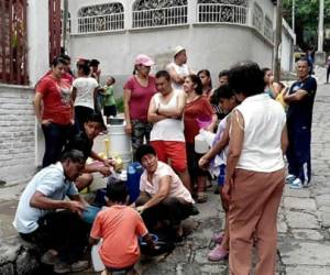 Los vecinos del barrio El Bosque han acudido a abastecerse de un pozo de la comunidad.