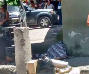 Uno de los hijos llora junto al cadáver de su madre la abogada Mirian del Cid asesinada este sábado atrás de los juzgados de la capital de Honduras.