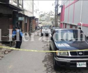 Elementos de la Policía acordonan la zona donde quedaron los cuerpos de dos hombres asesinados la tarde de este sábado en el mercado Álvarez de Comayagüela, capital de Honduras.