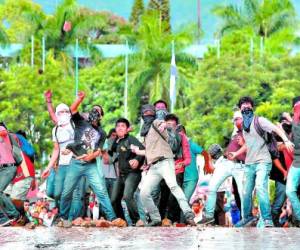 Personas encapuchadas y armadas con chimbas y piedras se enfrentaron a los miembros de la Policía Nacional.