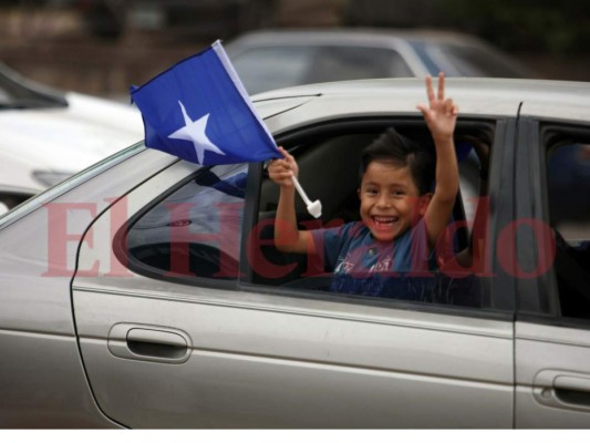 Un niño muestra con fervor la bandera del Partido Nacional de Honduras.