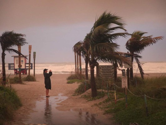 Una mujer toma una foto cuando los efectos del huracán Dorian comienzan a sentirse en Cocoa Beach, Florida. Foto: Agencia AFP.