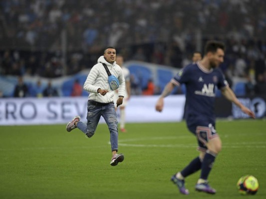 Un individuo corre hacia al delantero del PSG Lionel Messi durante el partido contra el Marsella por la liga francesa. Foto:AFP