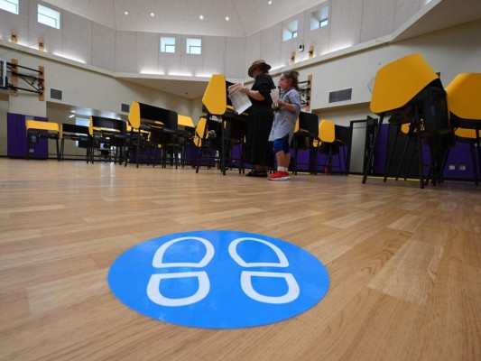 Una mujer acompañada por una niña emite su voto para las elecciones presidenciales de Estados Unidos en la Escuela Primaria Horace Mann. Foto: Agencia AFP.