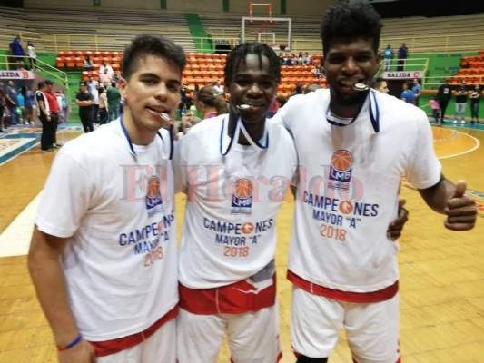 Ernesto Rápalo, Denesson Lucas y Cristian Williams celebran con la medalla de campeones al ganar la Liga Mayor Nathanael López con Banco Atlántida.