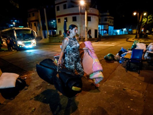 Un migrante venezolano carga colchones para descansar en un parque en Bucaramanga, Colombia. Decenas de migrantes venezolanos han convertido la ciudad colombiana de Bucaramanga. Foto: AFP.