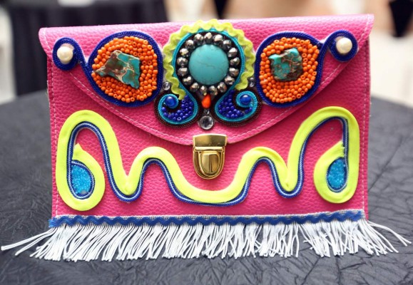 Un original clutch con flecos, trencilla y piedras de mostacilla que proporcionan un accesorio muy colorido.