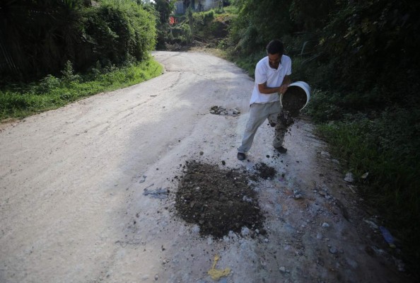 1. Los pobladores que viven en las orillas de esta carretera arrojan tierra en los tramos más destruidos. Foto: Johny Magallanes / EL HERALDO.