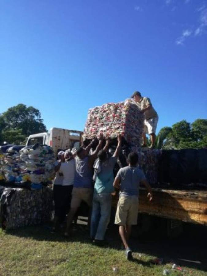 Sacan las botellas del mar en Utila y las usan para asfaltar sus calles