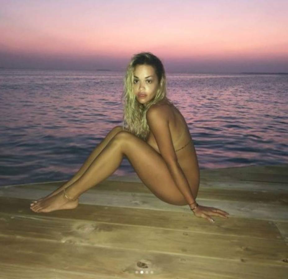 Rita Ora seduce a sus fans al posar sin ropa a la orilla del mar.