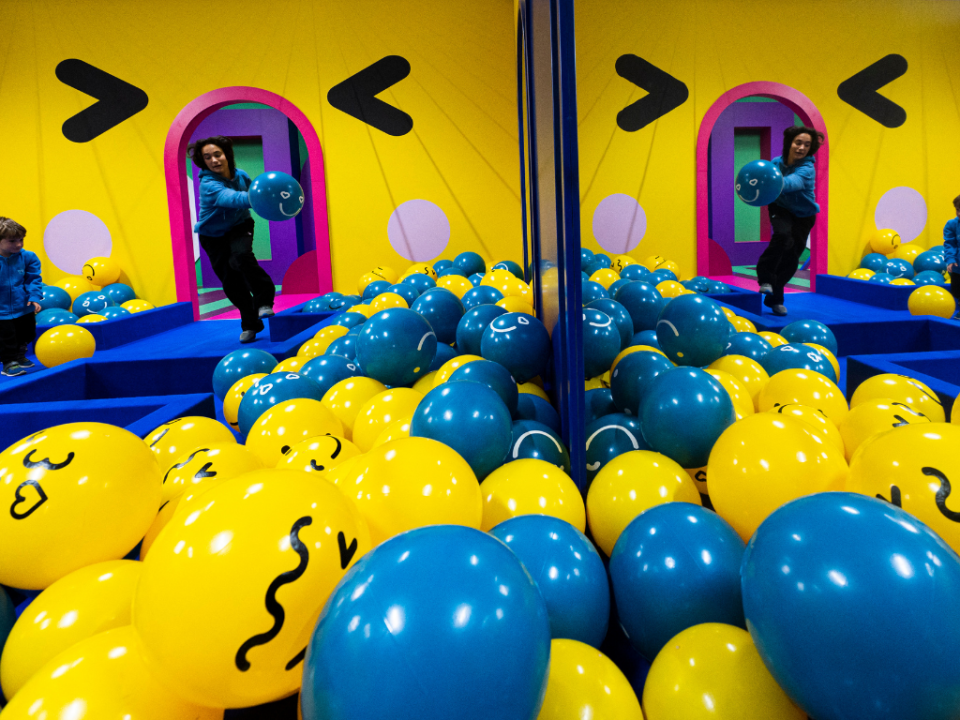 Detrás suyo está la “sala emoji”, repleta de bolas azules y amarillas representando las archiconocidas caras sonrientes.