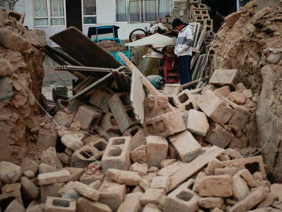 Un niño se encuentra entre los escombros de su casa derrumbada en Dahejia, en el condado de Jishishan, en la provincia de Gansu, en el noroeste de China, el 20 de diciembre de 2023.
