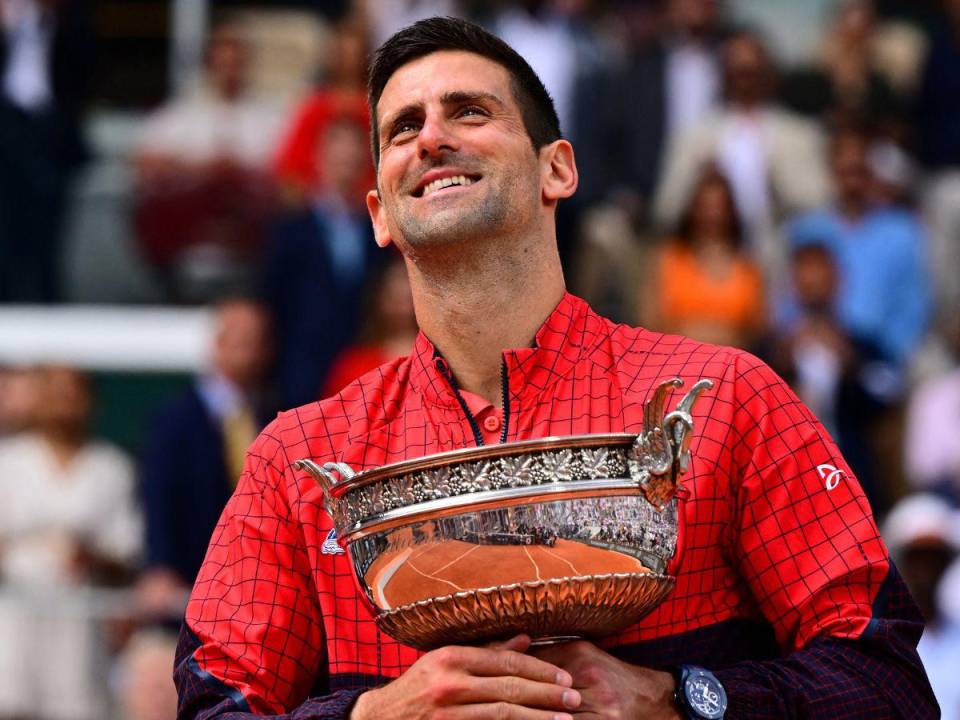 El serbio Novak Djokovic posa con su trofeo mientras celebra su victoria sobre el noruego Casper Ruud durante el partido final de individuales masculinos en el día quince del torneo de tenis Roland-Garros Open.