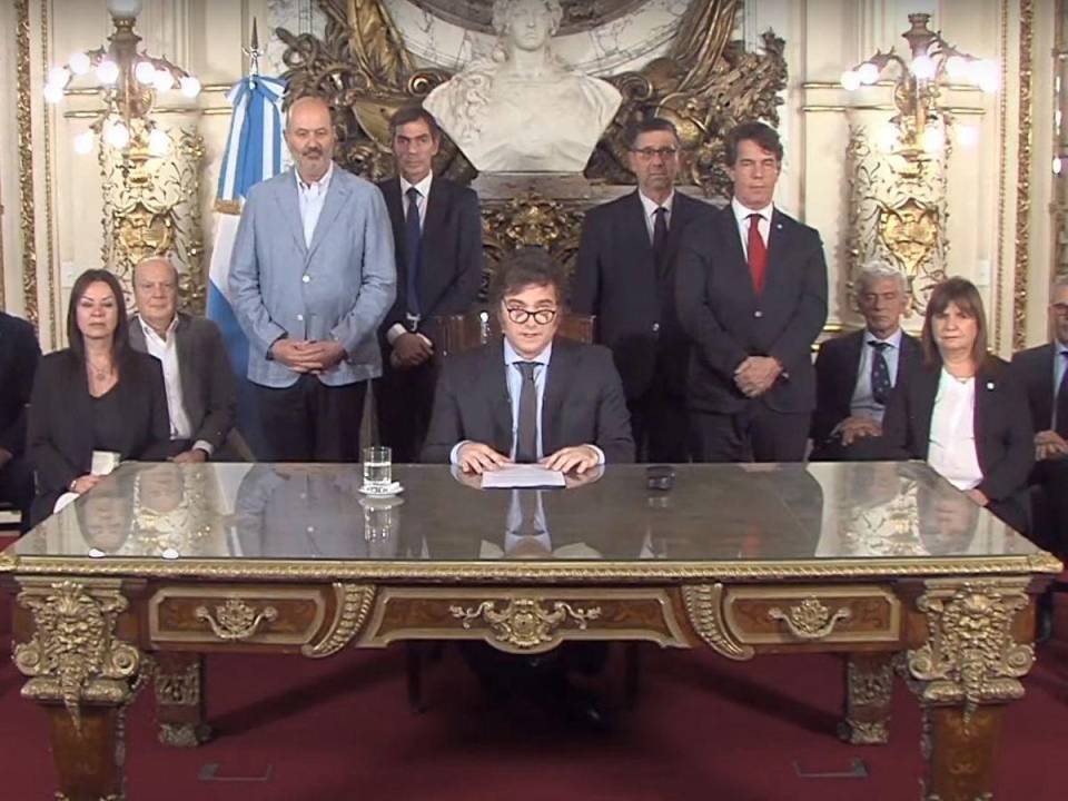 Esta captura de pantalla obtenida de un video transmitido por la Presidencia de Argentina muestra al presidente Javier Milei (C) entregando un mensaje a la nación desde el palacio presidencial de la Casa Rosada en Buenos Aires el 20 de diciembre de 2023.