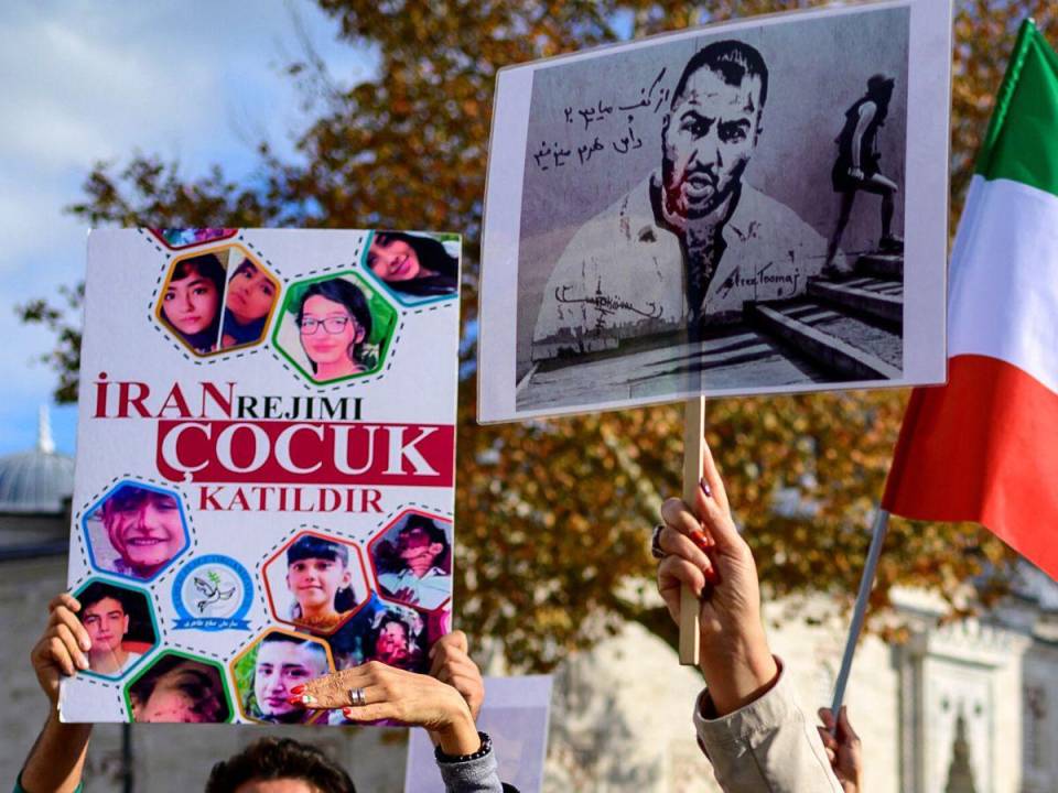 Las personas sostienen pancartas con retratos del rapero iraní Toomaj Salehi, arrestado en Irán.