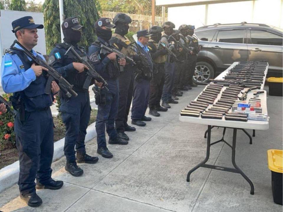 La Policía Nacional posa con el arsenal de armas que decomisaron en San Pedro Sula.