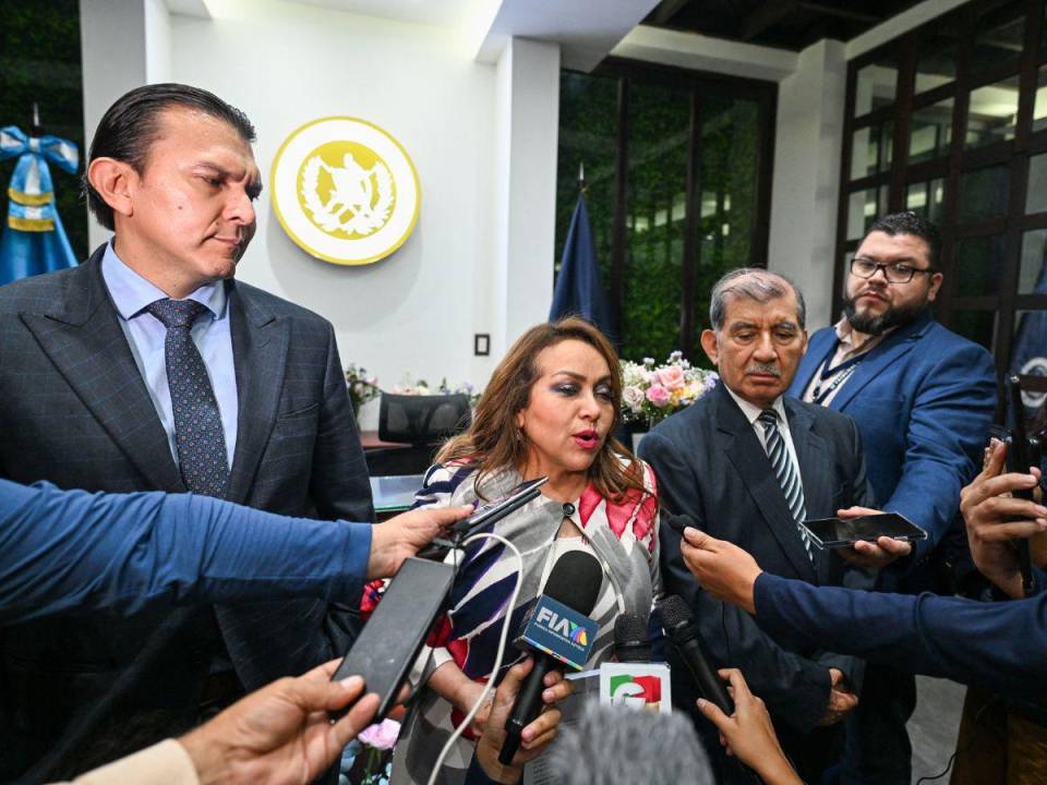 La presidenta del Tribunal Supremo Electoral, Irma Palencia (izq.), y el magistrado Mynor Franco posan para fotografías frente a la sede del Tribunal Constitucional en la Ciudad de Guatemala el 29 de septiembre de 2023.