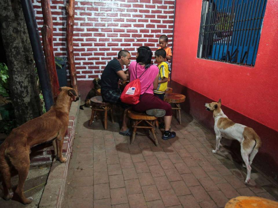 Migrantes venezolanos comen comida tradicional durante una parada de su autobús que los lleva a la frontera entre Nicaragua y Honduras
