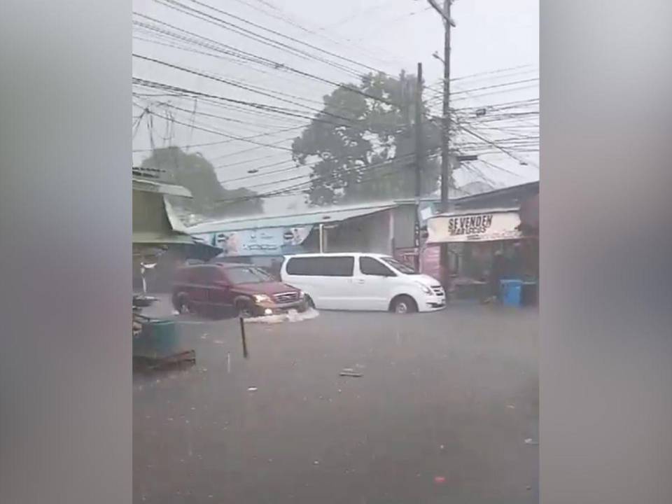 Los vehículos presentan problemas para transitar por las calles inundadas.