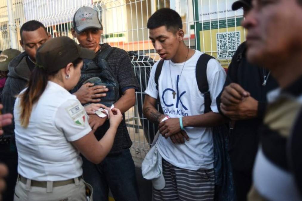 FOTOS: Con brazaletes en sus manos identifican a mujeres, hombres y niños de la caravana migrante en México