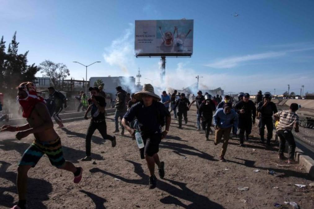 Fotos del momento en el que migrantes de la caravana saltaron valla fronteriza de Estados Unidos, pero fueron detenidos con gases lacrimógenos