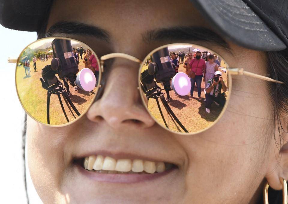 Una imagen del eclipse solar anular se refleja en las gafas de sol de una joven en el Observatorio Astronómico de la Universidad Nacional Autónoma de Honduras (UNAH).