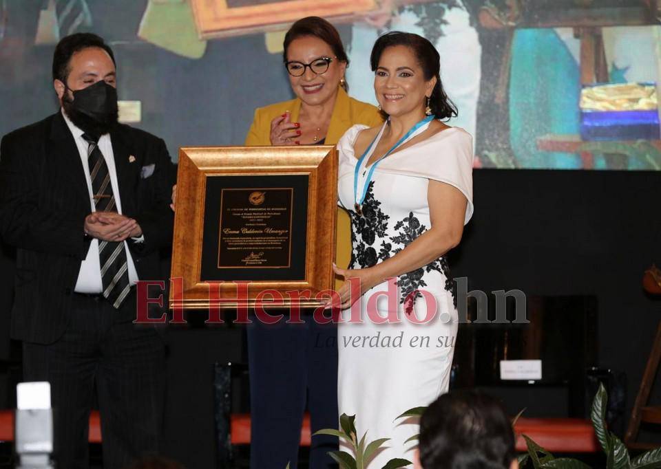 La periodista Enma Calderón mientras recibe su premio Álvaro Contreras al lado de la presidenta Xiomara Castro y Luis Redondo, presidente del CN.