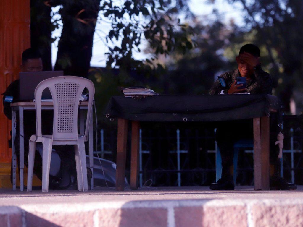 $!En el municipio de Goascorán, sur de Honduras, se logró observar a estos dos uniformados entretenidos con sus aparatos móviles en las cercanías del parque central.