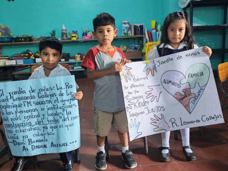 Los pequeños Elías Jafeth Martínez, Eduin Martín Amador y Sofía Almendares Silva, solicitan un techo digno para su escuelita donde reciben sus primeras enseñanzas.