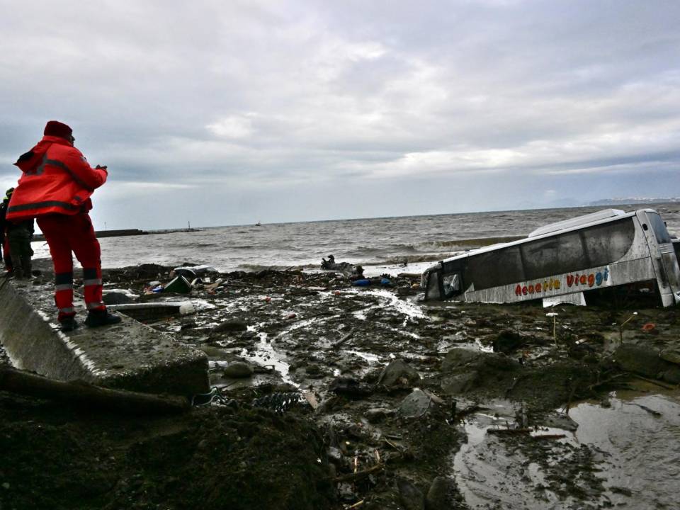 Los miembros de la escude observan los automóviles dañados en la isla de Ischia, en el sur, el 26 de noviembre de 2022, luego de las fuertes lluvias que provocaron un deslizamiento de tierra.