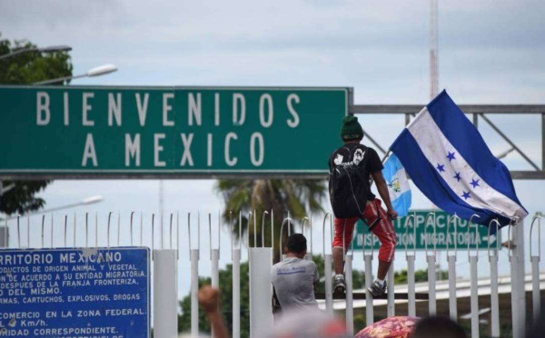FOTOS: Así fue el momento en el que la caravana migrante de hondureños rompió los portones e ingresó a México