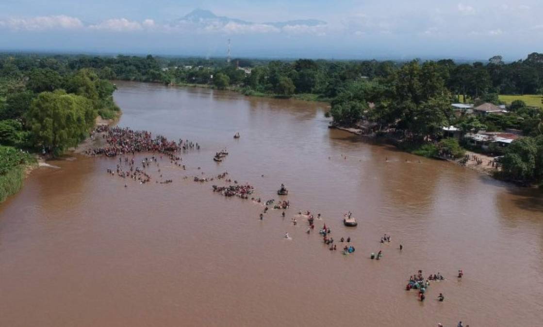 FOTOS: Con cadena humana migrantes intentan cruzar el río Suchiate que divide Guatemala y México