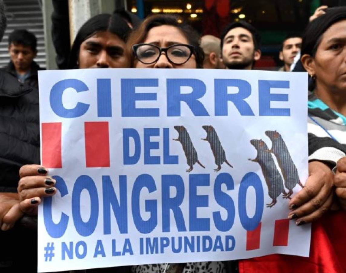 Protesters demand the dissolution of the Congress and demonstrate against lawmakers in Lima on September 30, 2019 after President Martin Vizcarra launches an ultimatum to Congress that he would dissolve it if he is denied a vote of confidence to reform the way in which the magistrates of the Constitutional Court are appointed. - Vizcarra had originally threatened to dissolve Congress and force new legislative elections in June, unless lawmakers backed his anti-graft proposals. The proposal to lift legislative immunity turned into the source of the latest conflict between Peru's executive and legislative branches; Vizcarra proposed giving the Supreme Court power to decide whether to strip a legislator of the protection. Congress, which currently holds the power to lift judicial immunity, rejected the idea. (Photo by Cris BOURONCLE / AFP)