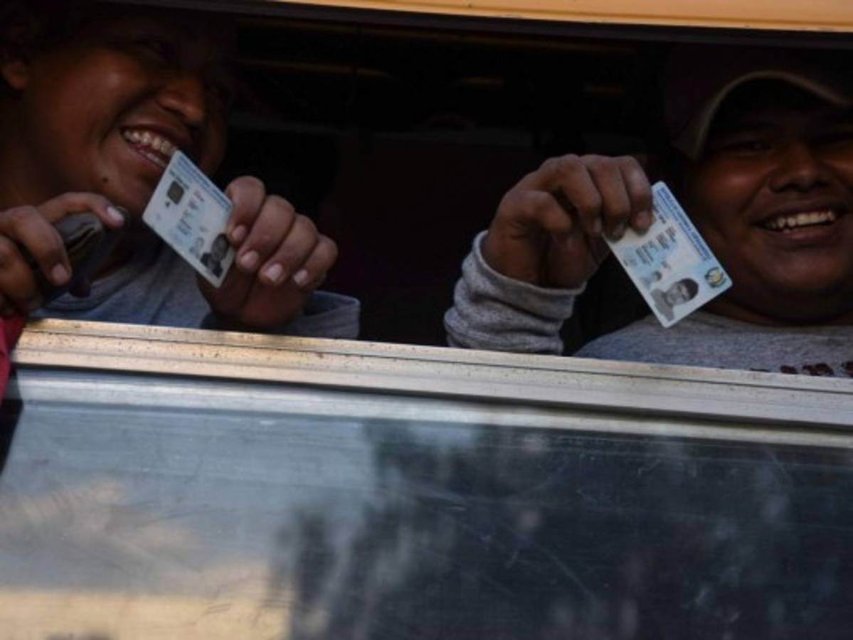 Guatemalan shows their identification as the Guatemalan soldiers deployed check the identification of public transport users in Chiquimula, Guatemala, as they wait for Honduran migrants taking part in a new caravan heading to the US, on October 22, 2018. - US President Donald Trump on Monday called the migrant caravan heading toward the US-Mexico border a national emergency, saying he has alerted the US border patrol and military. (Photo by ORLANDO ESTRADA / AFP)