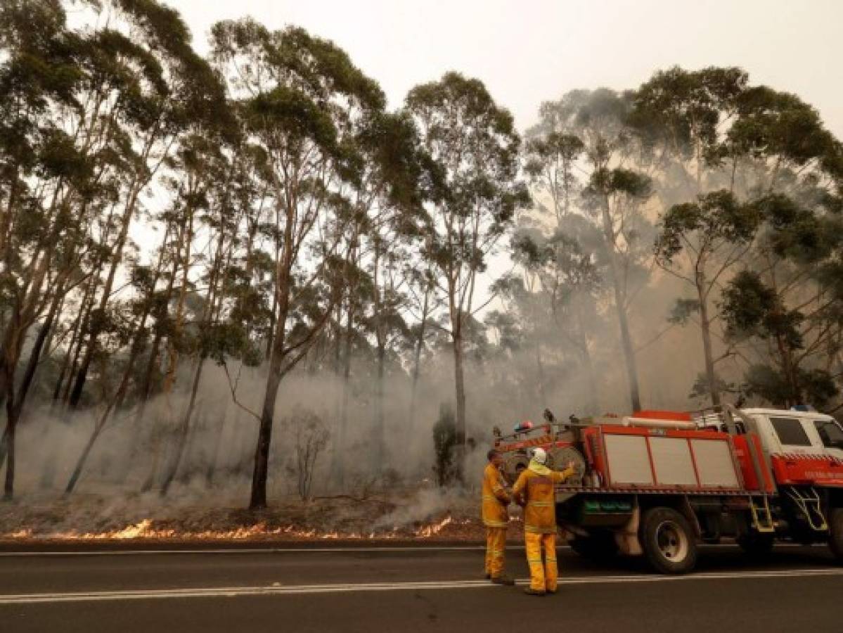 Una cuadrilla de bomberos combate un incendio forestal cerca de Burrill Lake, Australia, el domingo 5 de enero de 2020. (AP Foto/Rick Rycroft)