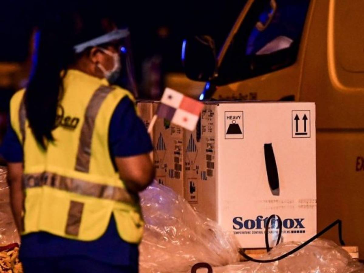 Los trabajadores descargan contenedores con el primer envío de la vacuna Pfizer / BioNTech para Panamá. Foto: AFP